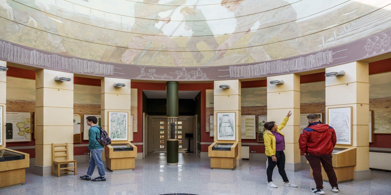 tall pillars with red outlines. Marble floors with people exploring